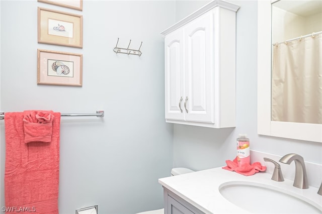 full bathroom with toilet and vanity