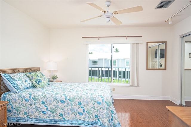 bedroom with baseboards, visible vents, a ceiling fan, wood finished floors, and rail lighting