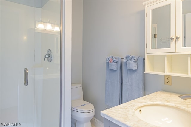 bathroom featuring a stall shower, vanity, and toilet