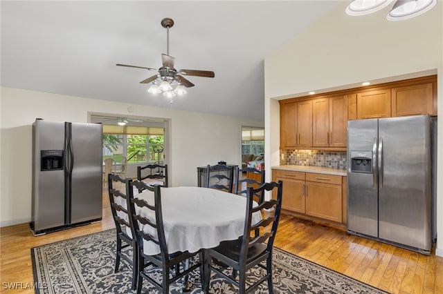 dining area with high vaulted ceiling, light wood-type flooring, and ceiling fan