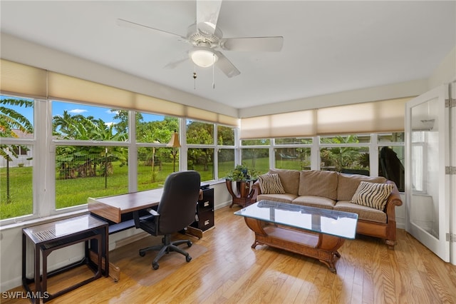 sunroom / solarium featuring a healthy amount of sunlight and ceiling fan