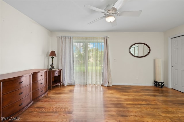 bedroom with radiator heating unit, wood-type flooring, and ceiling fan