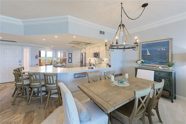 dining room featuring light colored carpet, ceiling fan with notable chandelier, crown molding, and a tray ceiling