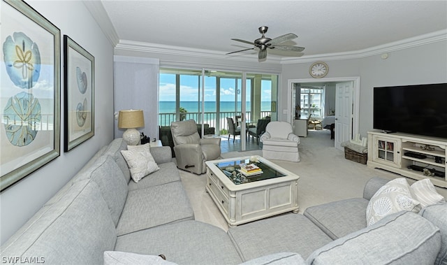 carpeted living room featuring a water view, crown molding, and ceiling fan