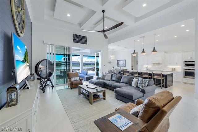 living room with ornamental molding, coffered ceiling, ceiling fan, beamed ceiling, and a high ceiling