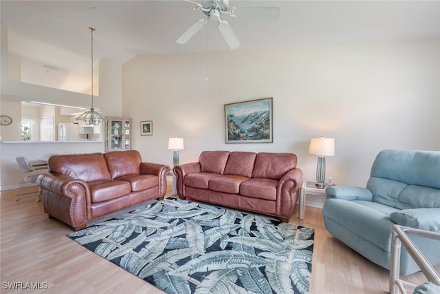 living room featuring vaulted ceiling, wood finished floors, a ceiling fan, and baseboards