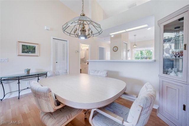 dining room featuring light wood-type flooring, visible vents, and a chandelier