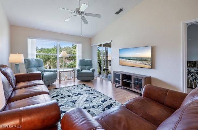 living room with ceiling fan, visible vents, vaulted ceiling, and wood finished floors