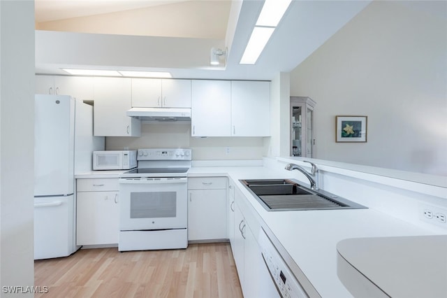 kitchen with under cabinet range hood, white appliances, a sink, and light countertops