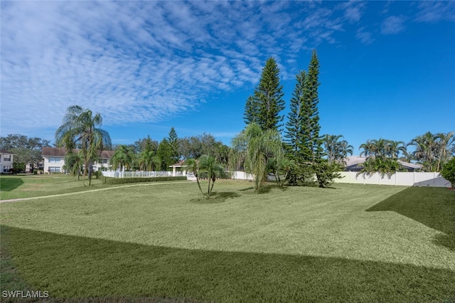 view of home's community featuring fence and a lawn