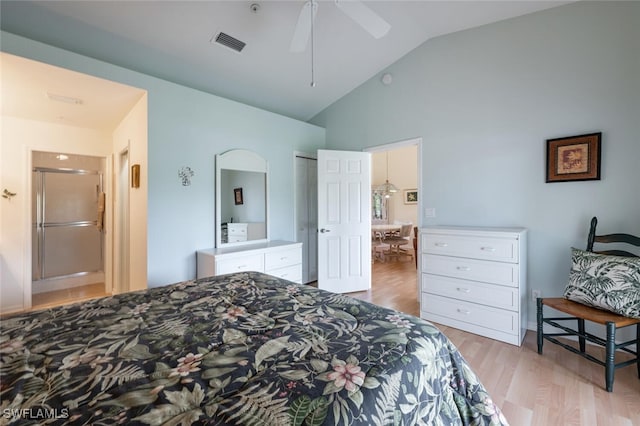 bedroom with lofted ceiling, arched walkways, connected bathroom, wood finished floors, and visible vents