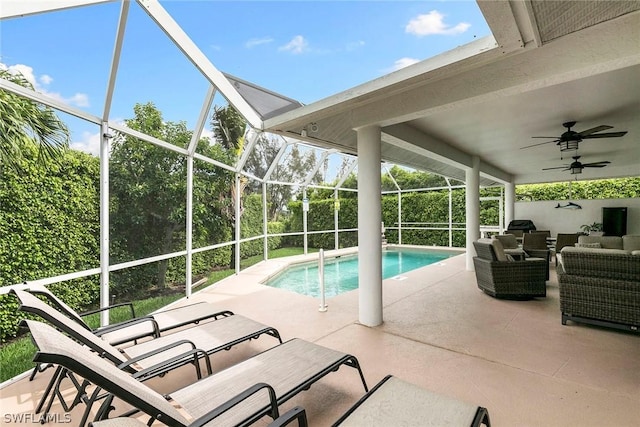 pool with glass enclosure, a patio, a ceiling fan, and an outdoor hangout area