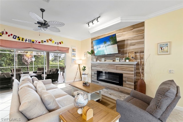 tiled living room with ceiling fan, track lighting, and ornamental molding