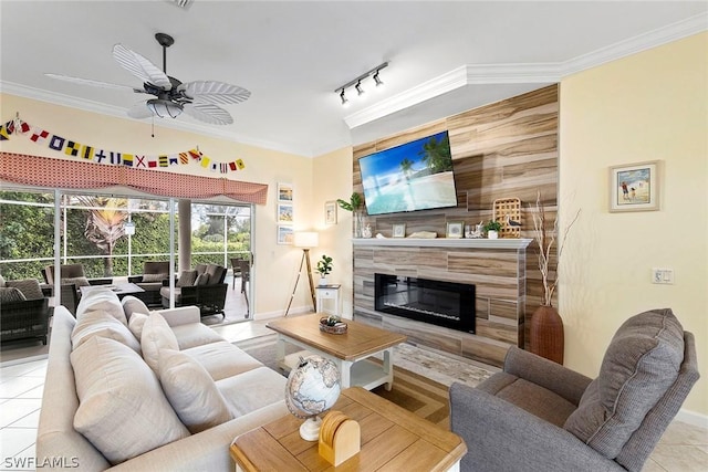 living room featuring a premium fireplace, ornamental molding, rail lighting, tile patterned floors, and a ceiling fan