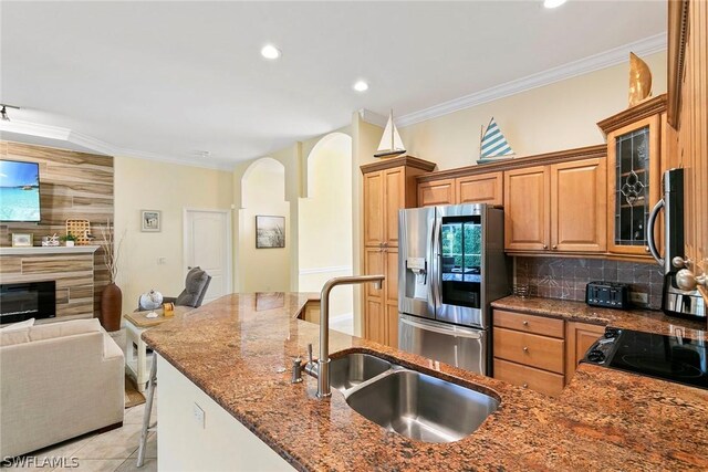 kitchen with stainless steel appliances, a kitchen breakfast bar, stone countertops, tasteful backsplash, and sink