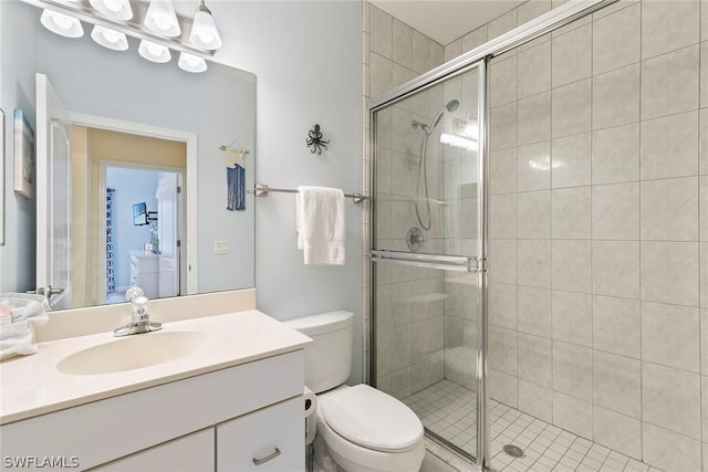 bathroom with vanity, toilet, and a stall shower