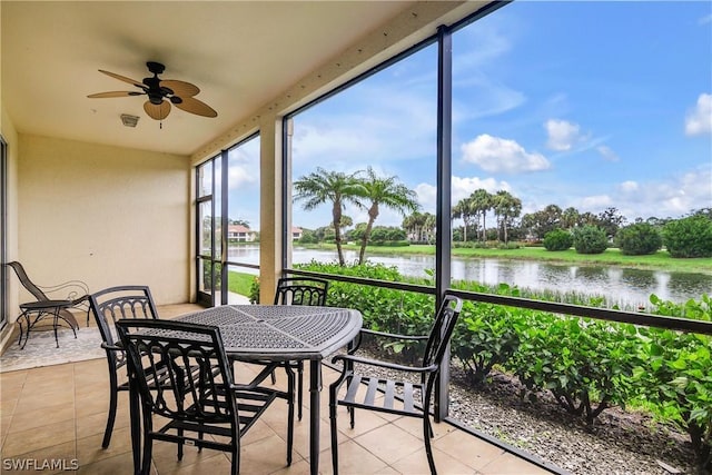 sunroom / solarium featuring ceiling fan and a water view