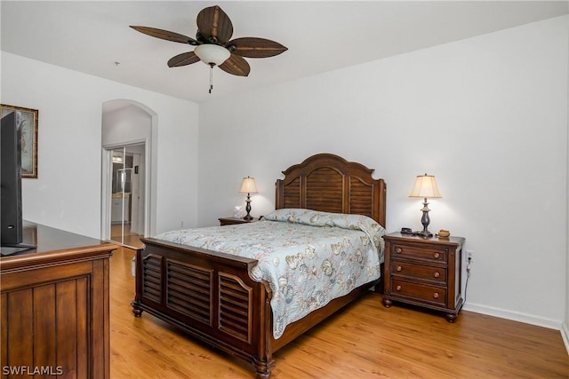 bedroom with connected bathroom and light hardwood / wood-style flooring