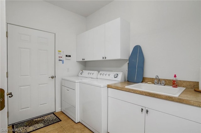 washroom featuring cabinets, separate washer and dryer, sink, and light tile patterned floors