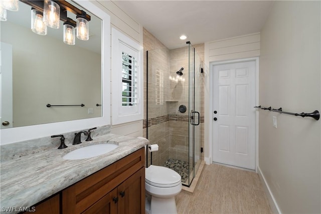 bathroom with hardwood / wood-style flooring, vanity, toilet, and walk in shower