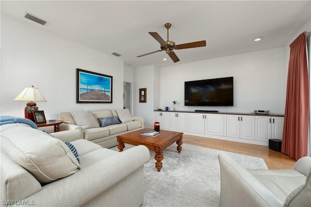 living room with light hardwood / wood-style floors and ceiling fan