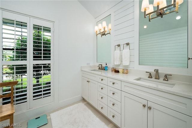 bathroom with a notable chandelier, vanity, and lofted ceiling