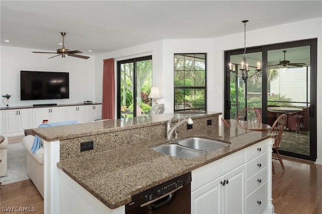 kitchen featuring white cabinetry, dishwasher, sink, hanging light fixtures, and an island with sink