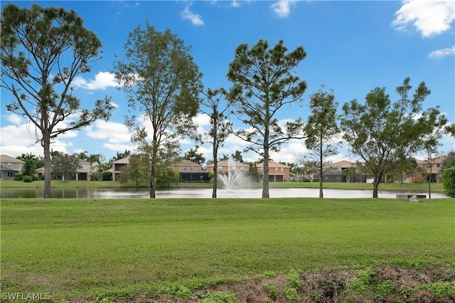 view of property's community featuring a yard and a water view