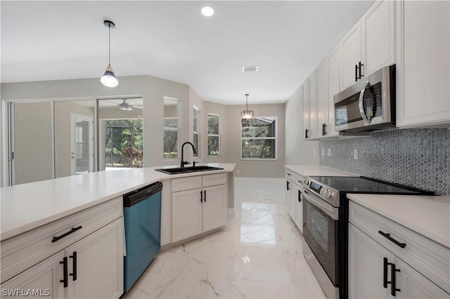 kitchen with pendant lighting, white cabinets, and stainless steel appliances