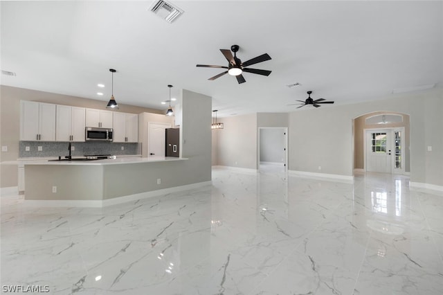 unfurnished living room featuring french doors and ceiling fan