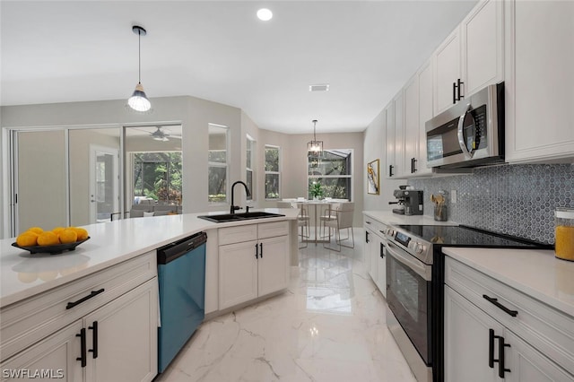 kitchen featuring backsplash, white cabinetry, hanging light fixtures, and stainless steel appliances