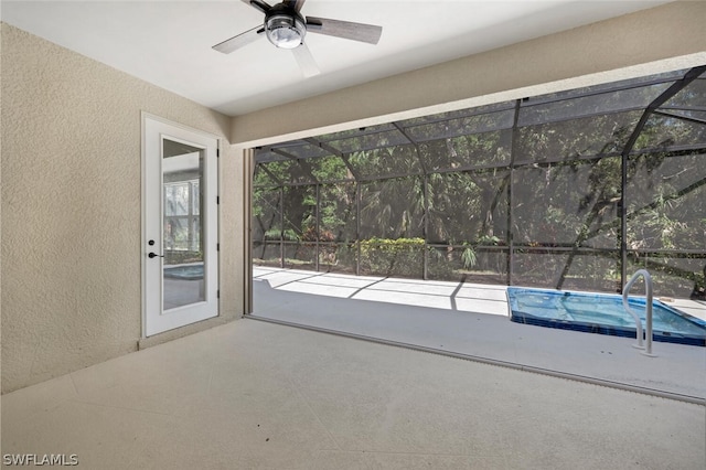 unfurnished sunroom with ceiling fan