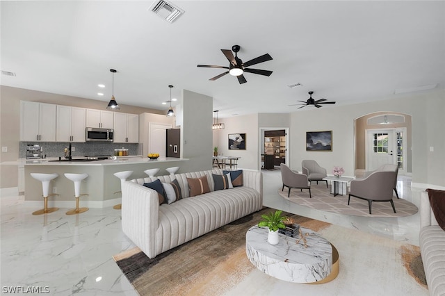 living room featuring ceiling fan and french doors