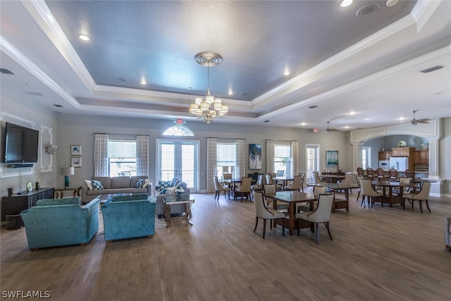 dining room featuring a raised ceiling, crown molding, and a wealth of natural light