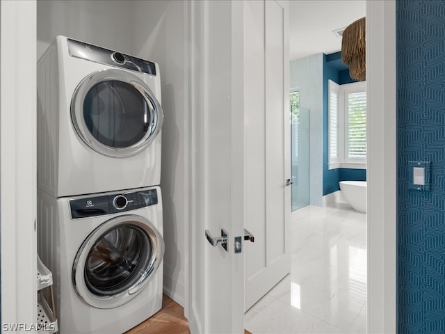 laundry area with light tile patterned flooring and stacked washer and clothes dryer