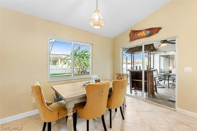 tiled dining room featuring ceiling fan and vaulted ceiling