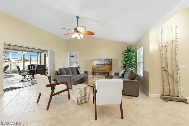 living room with ceiling fan, light tile patterned flooring, and lofted ceiling