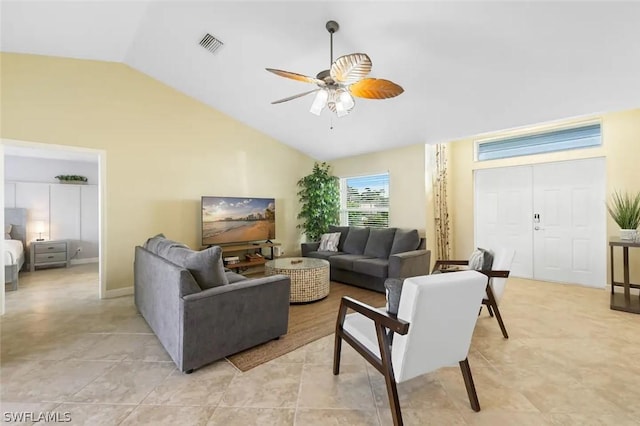 living room featuring ceiling fan, light tile patterned floors, and vaulted ceiling