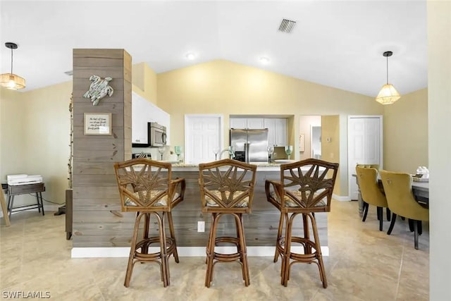 kitchen featuring pendant lighting, vaulted ceiling, and appliances with stainless steel finishes