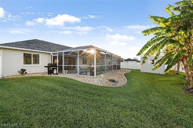 rear view of property featuring a yard and glass enclosure