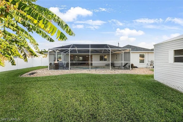 back of house with a lawn and glass enclosure