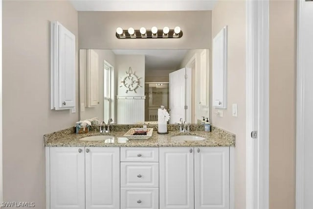 bathroom featuring vanity and a shower with shower door