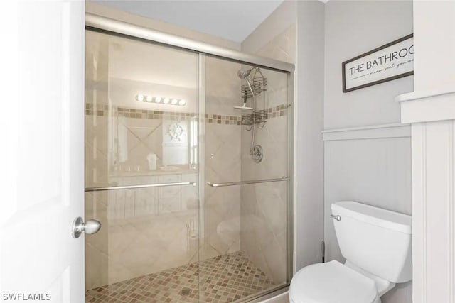 bathroom with toilet and a shower with shower door