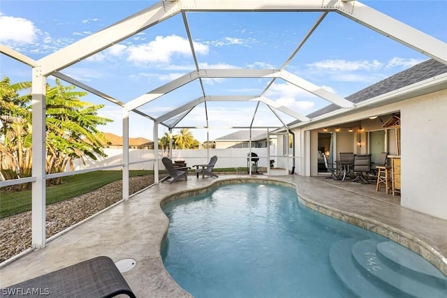 view of swimming pool featuring glass enclosure and a patio area