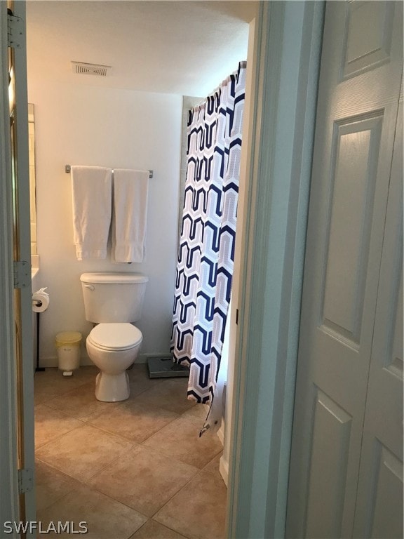 bathroom featuring toilet and tile floors