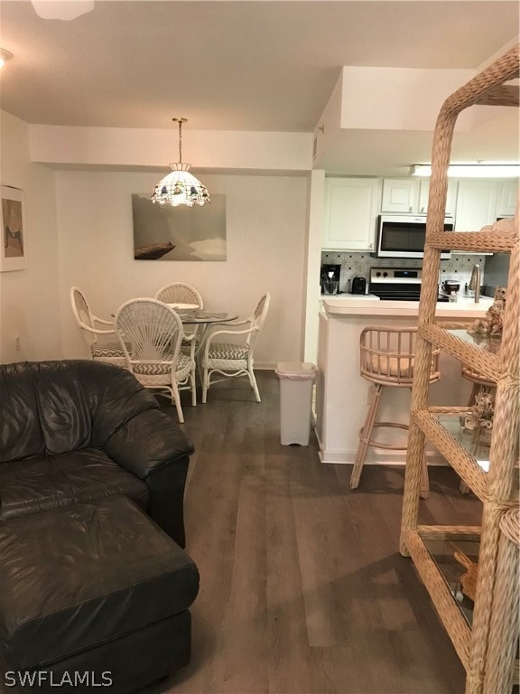 living room featuring a notable chandelier and dark hardwood / wood-style floors