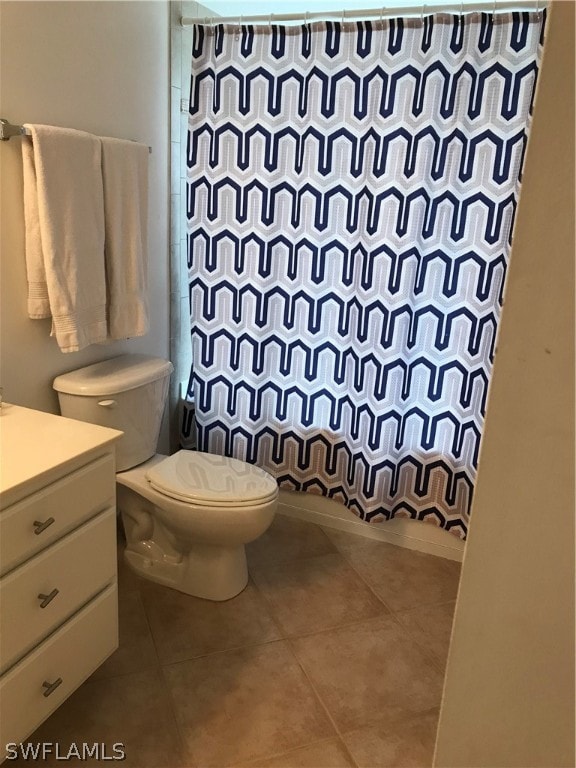 bathroom featuring tile floors, vanity, and toilet