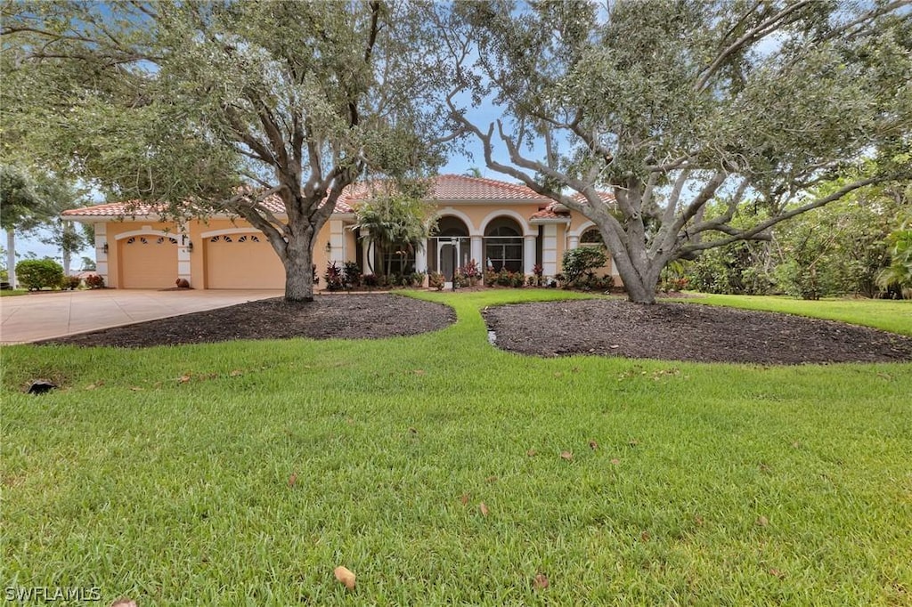 mediterranean / spanish-style house with a garage and a front yard