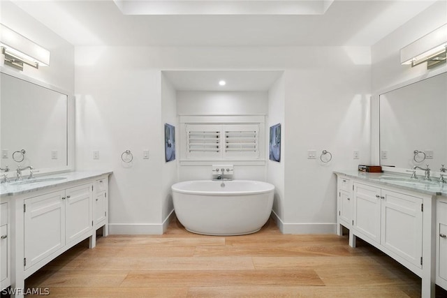 bathroom featuring hardwood / wood-style flooring, a washtub, and vanity