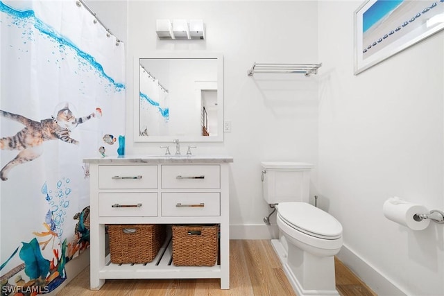 bathroom with vanity, toilet, and hardwood / wood-style floors